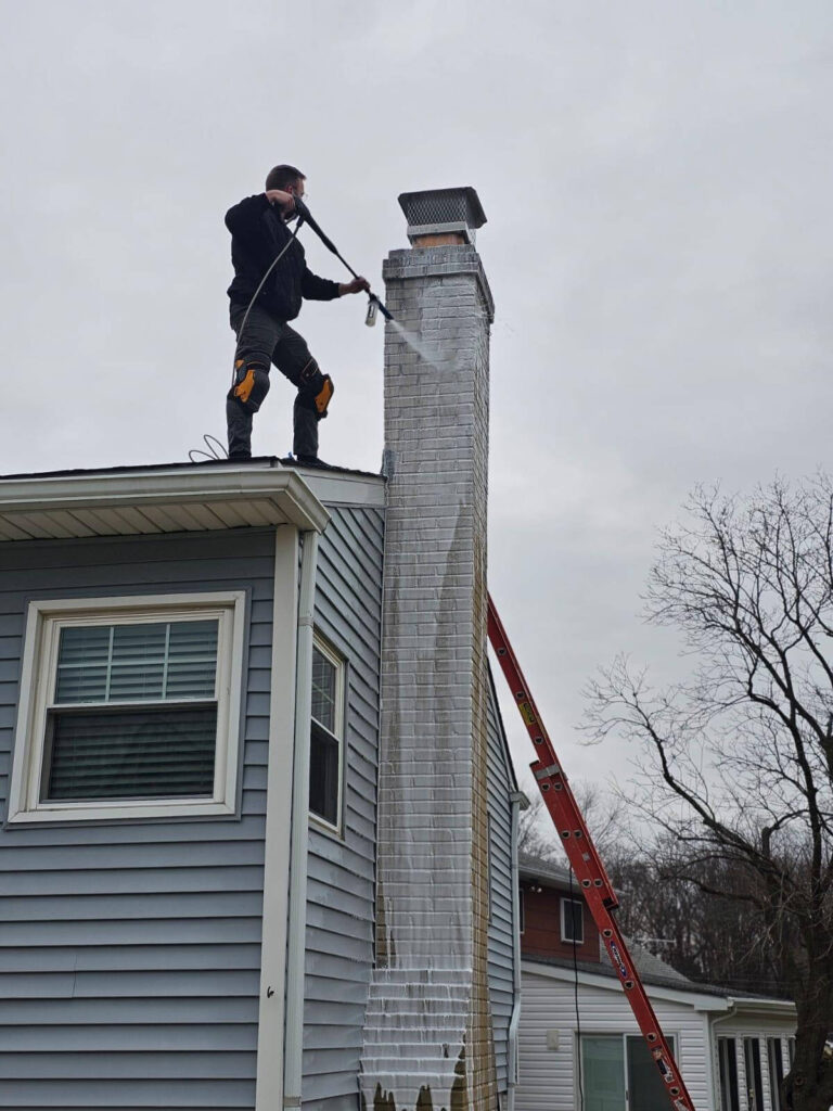 A chimney sweep cleaning the stack of a chimney