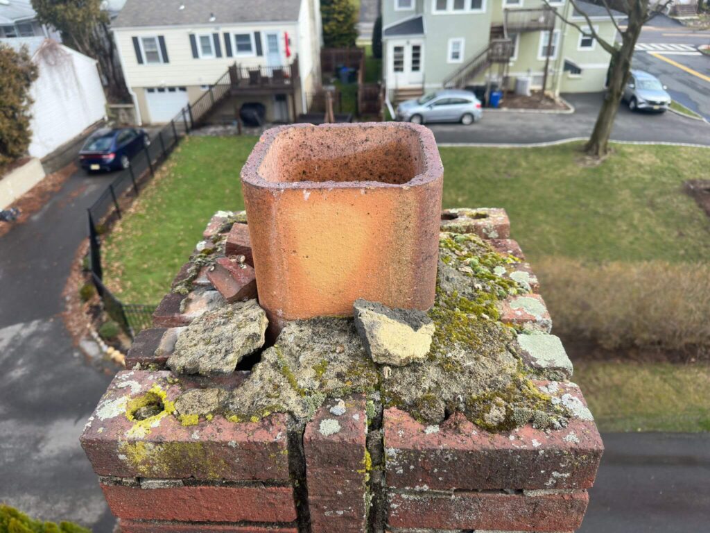 a badly damaged chimney crown with a missing cap