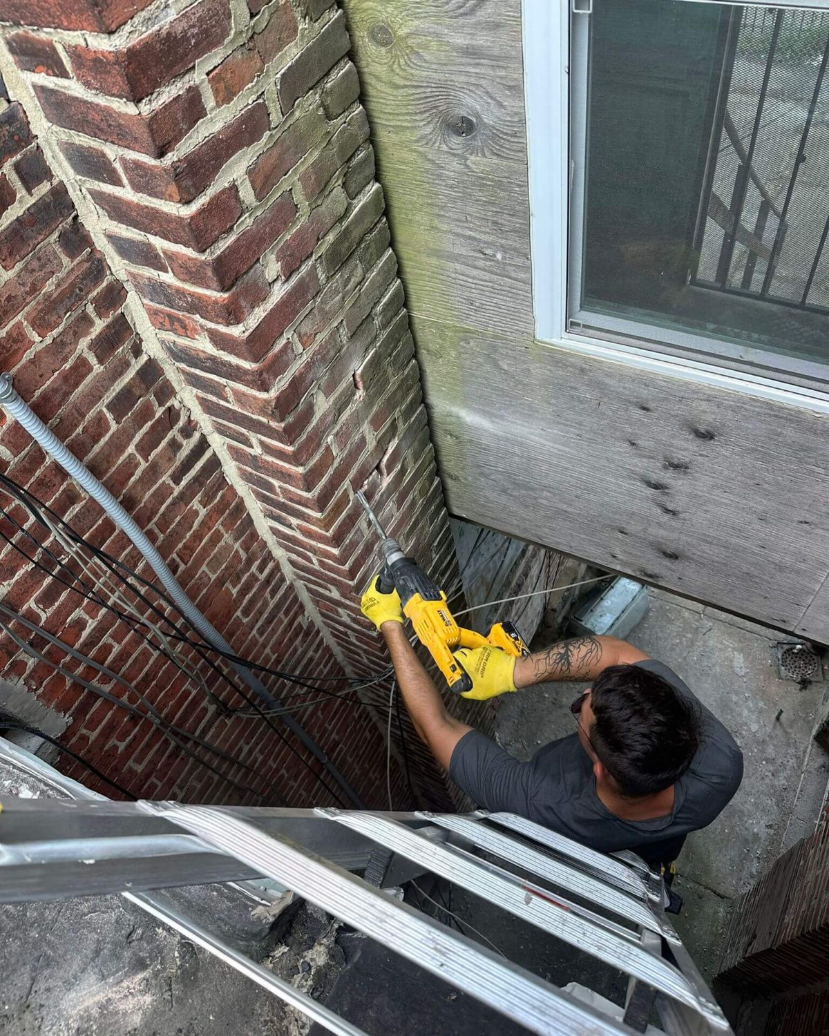 A chimney sweep is servicing the stack of a chimney