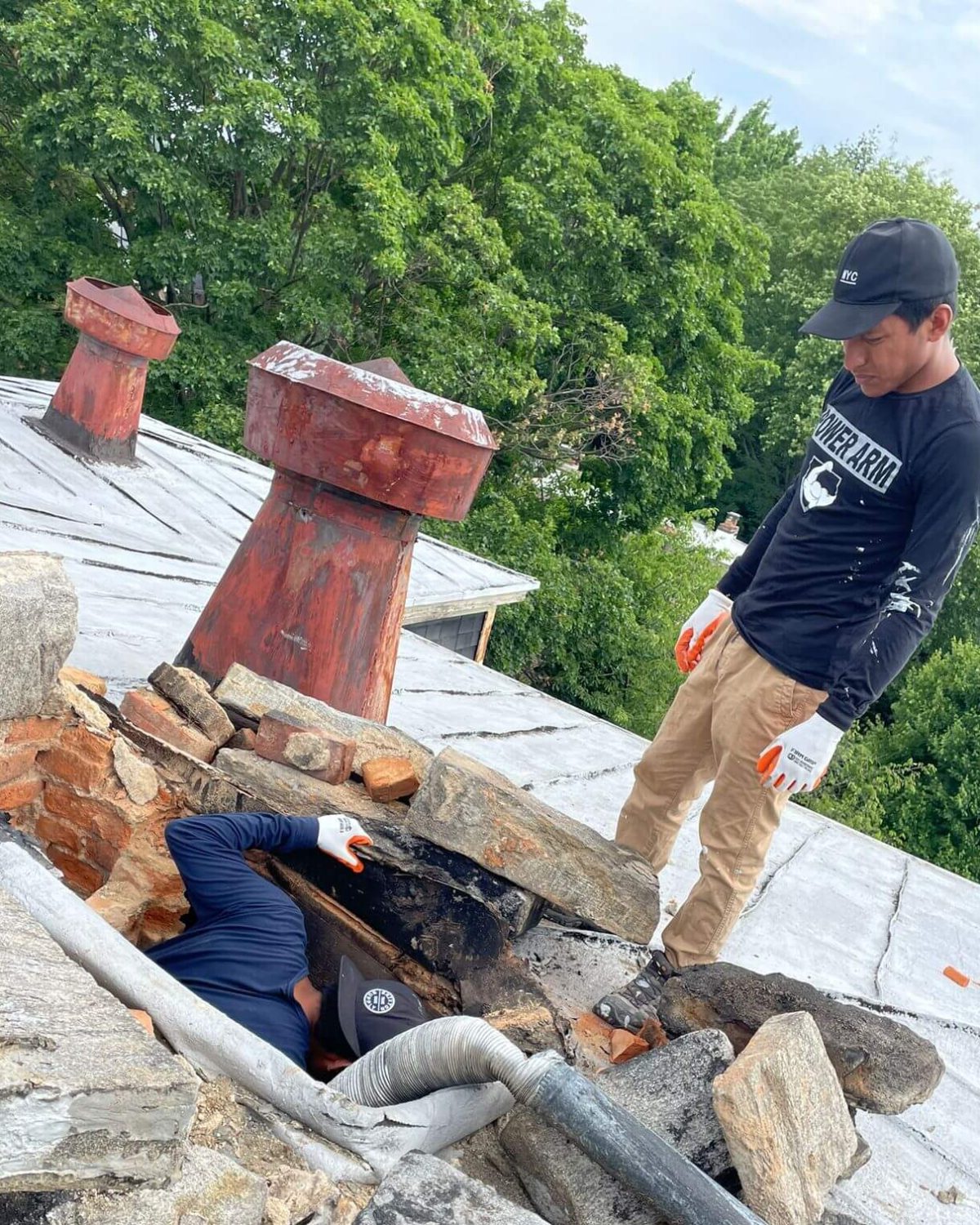 A chimney sweep is inspectiong a chimney to figure out what service it might need