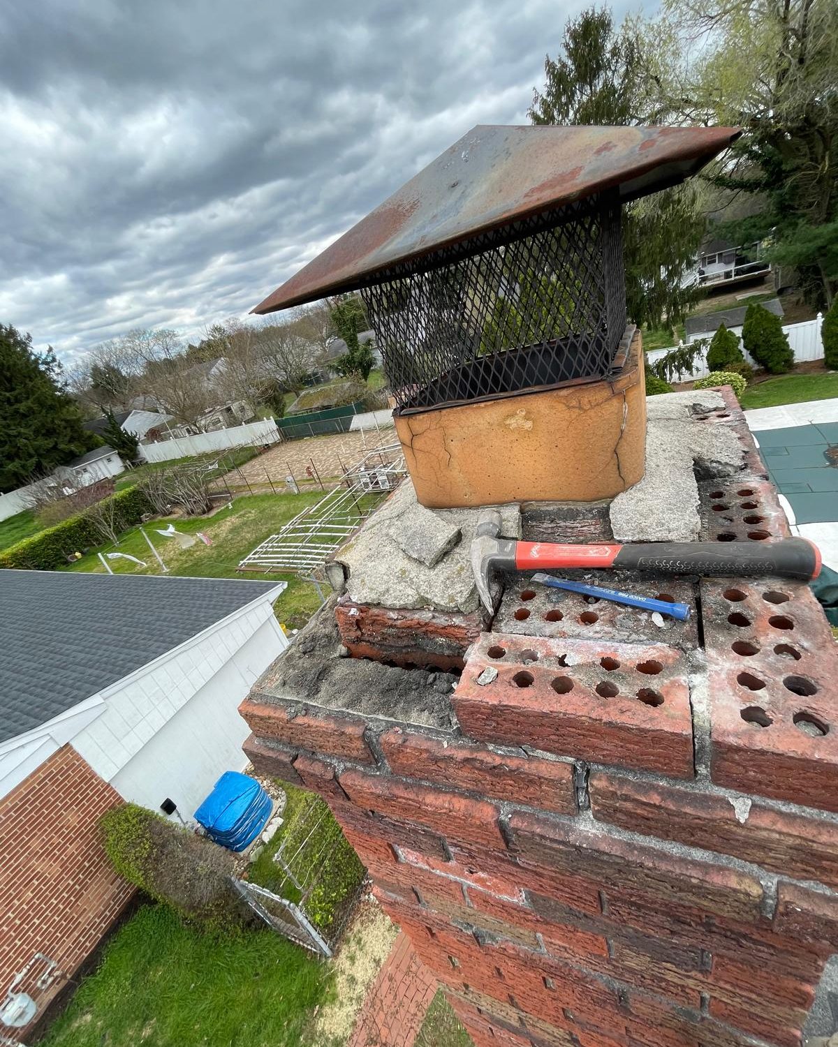 A chimney crown being rebuilt and serviced by a chimney sweeo